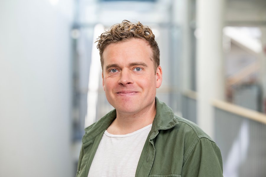 Ett foto av en leende person i grön skjorta. 