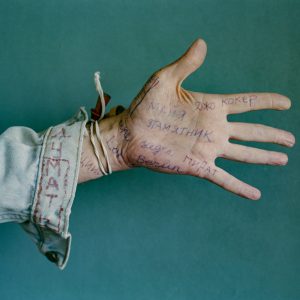 Syntolkad bildtext: En utsträckt hand och arm. På handen är det fullt med ord skrivet med kulspetspenna. Armen är klädd i jeansjacka som det också står ord på. 